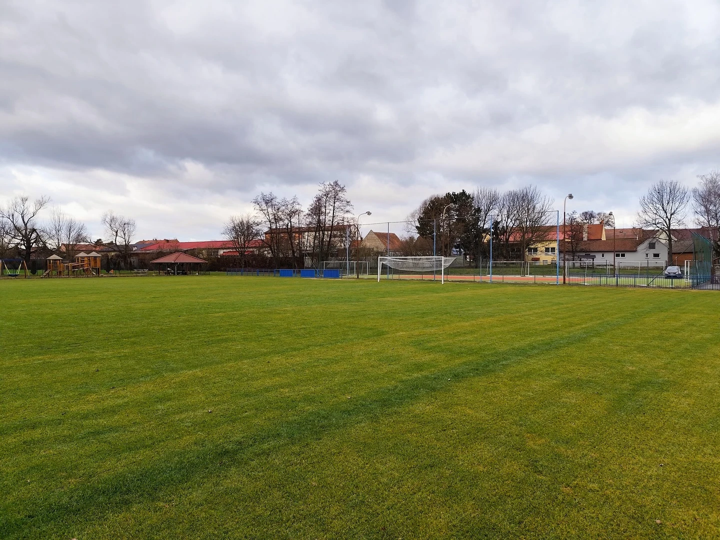 Fotbalové hřiště s umělým trávníkem zachycené během dne. Sportovní prostor vhodný pro tréninky a rekreační aktivity.